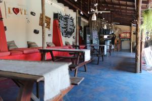 a row of tables and benches in a restaurant at Tri M Waves Lodge in Ponta do Ouro
