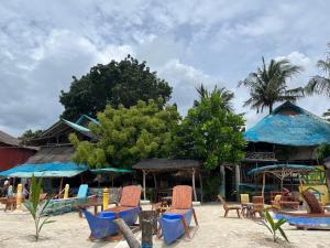 a group of chairs and tables on a beach at Bamboo Nest Beachfront Floating Tent in Puerto Princesa City