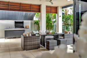 a kitchen and living room with a table and chairs at Belle Escapes Marina Quay in Yorkeys Knob