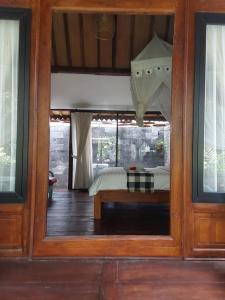 a view of a bedroom through a glass door at Buratwangi Joglo House in Kerobokan