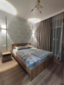 een slaapkamer met een groot bed in een kamer bij Tandau apartment in Taldykolʼ