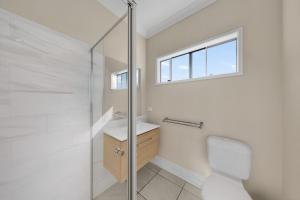a bathroom with a toilet and a sink and a window at Hidden Woodland Paradise - 2024 New Built 4 Bedroom Home Loganlea in Loganlea +9 photos