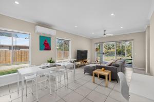 a living room with a couch and a table at Hidden Woodland Paradise - 2024 New Built 4 Bedroom Home Loganlea in Loganlea
