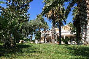 um edifício com palmeiras em frente em Città Bianca Country Resort em Ostuni