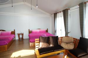 a bedroom with two beds and a couch at Ban Rai Rabeang Mok in Khao Kho +15 photos