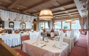 une salle à manger avec des tables et des nappes blanches dans l'établissement Hotel Onach, à San Lorenzo di Sebato