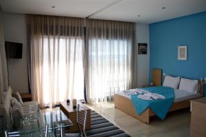 a bedroom with blue walls and a bed and a window at SunOrama Apts-Studios in Bali