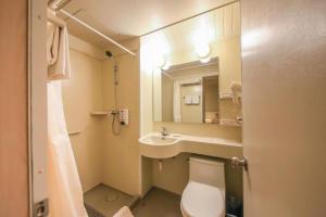 a bathroom with a toilet and a sink and a mirror at Jinjiang Inn Ulanqab Jining 1st Middle School in Ulanqab +108 photos