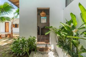 a hallway in a house with plants at The Lotus Backyard Uluwatu in Badung +5 photos