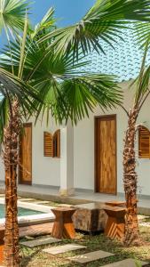a house with two palm trees in front of it at The Lotus Backyard Uluwatu in Badung