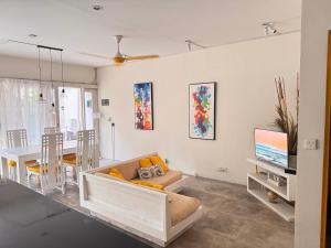 a living room with a couch and a table with a tv at Palm Villa 5 Seminyak Center in Seminyak