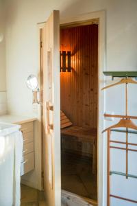 een open deur naar een badkamer met een houten bankje bij Creative Hideaway By Hållsviken Bay in Trosa +27 foto's