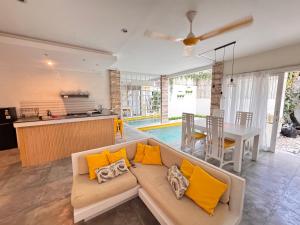 a living room with a couch and a kitchen and a table at Palm Villa 5 Seminyak Center in Seminyak