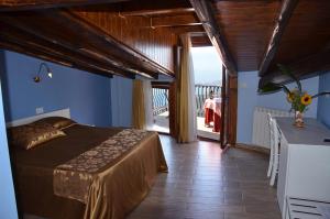 1 dormitorio con cama y vistas a un balcón en B&B Casa Bellavista, en Castelmola