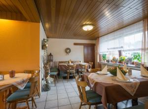 a restaurant with tables and chairs and a large window at Hotel Haus Gertrud in Simmerath +24 photos