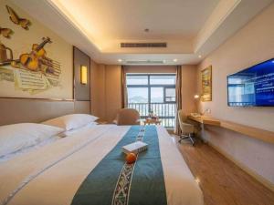 une chambre d'hôtel avec un grand lit et un bureau dans l'établissement Vienna Hotel Nanning Xiangsi Lake University Town, à Nanning 231 autres photos