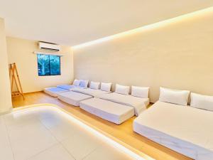 a living room with three beds and a couch at TheDOT261 Private Pool & Kids Pool Villa BRAND NEW A'Famosa Melaka in Kampong Pulau Sebang +15 photos