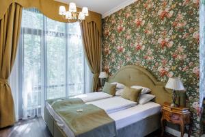 a bedroom with a bed with a floral wallpaper at Tilia Kúria - Adults only in Bózsva