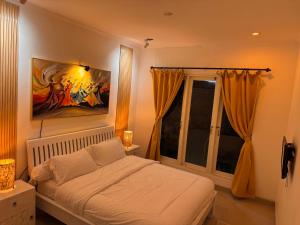 a bedroom with a bed and a painting on the wall at Palm Villa 5 Seminyak Center in Seminyak +16 photos
