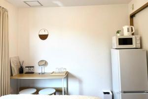 a kitchen with a refrigerator and a table with two toilets at Tanpopo Inn in Tokyo