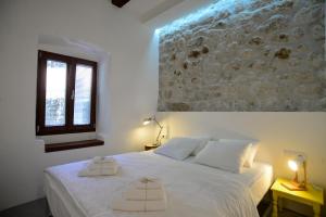 een slaapkamer met een wit bed en 2 handdoeken bij House 561 in Kotor