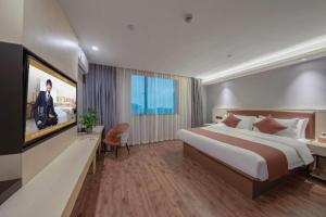 une chambre d'hôtel avec un grand lit et une télévision dans l'établissement Gya Hotel Shanghai Long Distance Passenger Terminal Station, à Shanghai