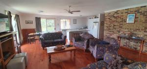 ein Wohnzimmer mit Sofas und einer Ziegelwand in der Unterkunft Rainbow Cottage - Rainbow Beach. Pets welcome in Rainbow Beach