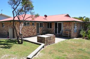 ein Backsteinhaus mit rotem Dach in der Unterkunft Rainbow Cottage - Rainbow Beach. Pets welcome in Rainbow Beach