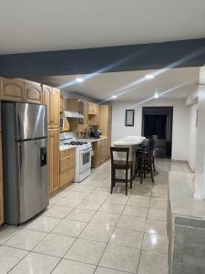 Una cocina con refrigerador de acero inoxidable y una mesa. en Ocean front apartment., en San Antonio del Mar