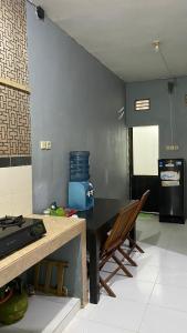a kitchen with a black table and chairs in a room at LA LUNA Guest House in Banyuwangi