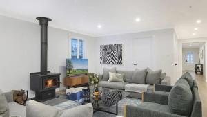 een woonkamer met een bank en een open haard bij Coachwood Cottage in Robertson