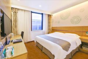 une chambre d'hôtel avec un grand lit et une télévision dans l'établissement GreenTree Inn Beijing Tongzhou District Ciqu Subway Station Express Hotel, à Pékin