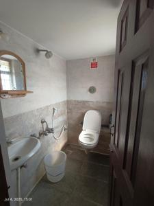 a bathroom with a toilet and a sink at Hotel Fini Villa in Bengaluru