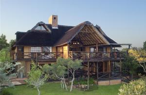 a large house with a thatched roof at Zwahili Private Game Lodge & Spa in Modimolle