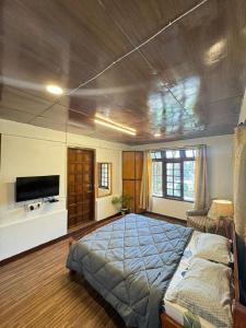 a bedroom with a large bed and a tv at BelleVue Home Stay in Shillong
