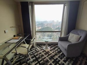 a room with a desk and a chair and a window at GreenTree Alliance Hotel Guiyang Huaguo Community Central Business Zone in Guiyang