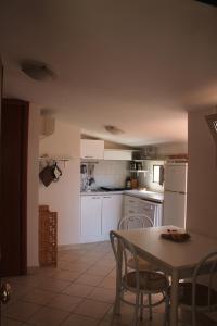 uma cozinha com electrodomésticos brancos e uma mesa e cadeiras em Mansarda 25 em Terracina