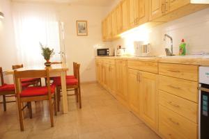 a kitchen with wooden cabinets and a table with a dining room at Apartments Segedin in Korčula