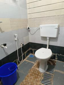 a bathroom with a toilet and a bucket at Josco Residency Karthikapuram in Paithalmala
