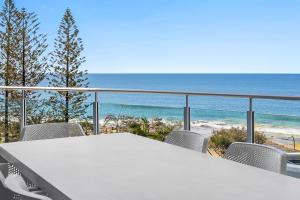 Una mesa y sillas en un balcón con vista al mar. en Sirocco 506, en Mooloolaba