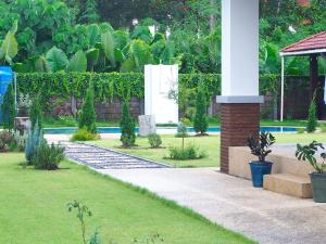 un jardín con un camino que conduce a una casa en Per La Villa Khao Lak, en Khao Lak