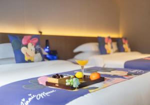 uma bandeja com uma bebida e fruta numa cama em Zhang jia jie gui yuan zhen pin hotel -Approximately 3km away from the east gate of Zhangjiajie National Forest Park,Free local specialty breakfast, Attraction Tickets Serivce in advance,Free one-way shuttle service for 4 nights or more em Zhangjiajie