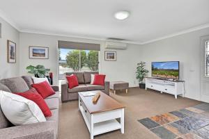 a living room with a couch and a tv at Andres Farm Cottage in Broke
