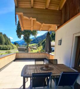 a table and chairs on a patio with a view at Ferienwohnung Frauenkogelblick mit Terrasse in Grossarl