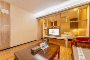 a living room with a couch and a table at Wenxing Hotel Dongguan Qifeng Branch in Dongguan
