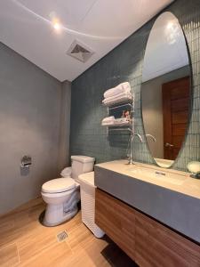 ein Badezimmer mit Waschbecken, Toilette und Spiegel in der Unterkunft Busay Getaway in Cebu City + 22 Fotos