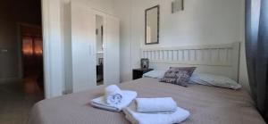una camera da letto con due letti con asciugamani sopra di Ideal for Families-Children's Play Area, Terrace, BBQ, WiFi a San Isidro Altre 106 foto