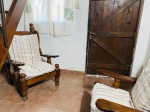 ein Wohnzimmer mit 2 Stühlen und einer Tür in der Unterkunft Iberá in Mercedes