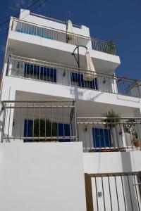 a white building with balconies on top of it at SunOrama Apts-Studios in Balíon