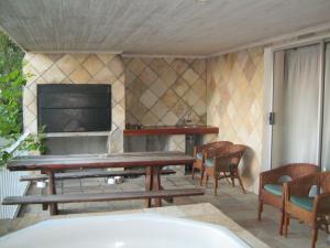 a living room with a fireplace and a table and chairs at Shirleys Place in Brackenfell
